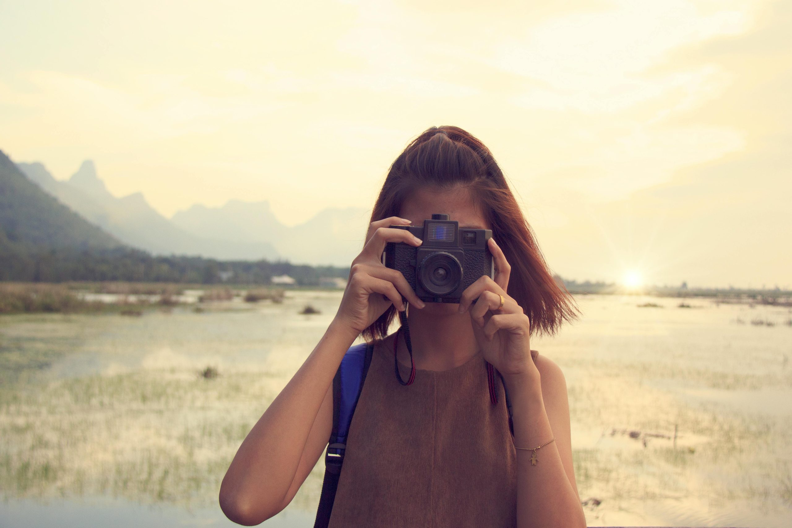 Joven fotógrafa capturando la belleza del paisaje con su cámara.